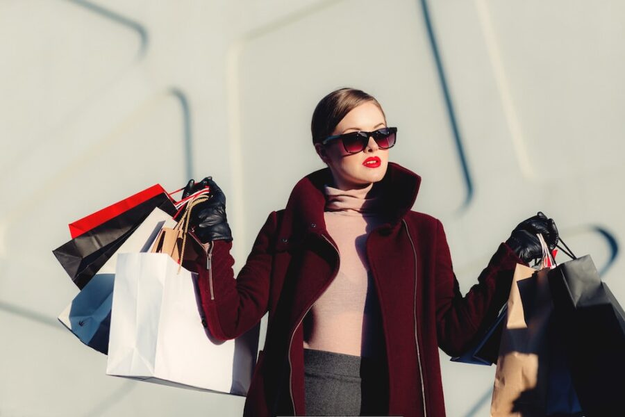 photo of woman holding white and black paper bags, shopping addictions